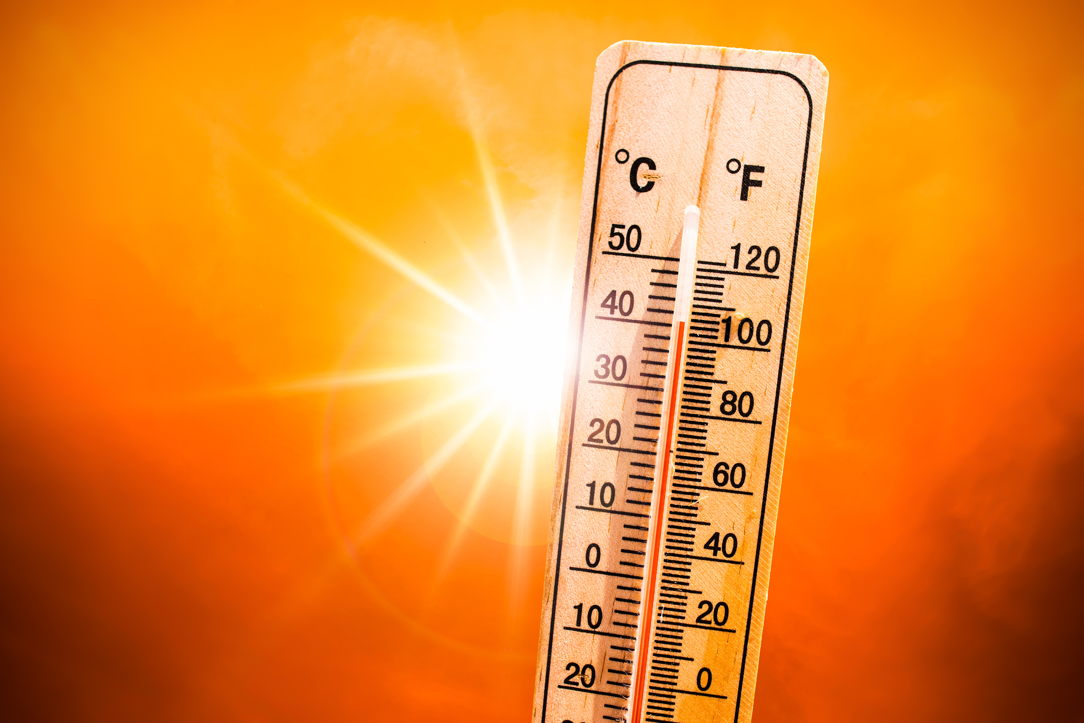 image of a mercury thermometer reading 106 degrees in front of a bright sun on a burnt orange background